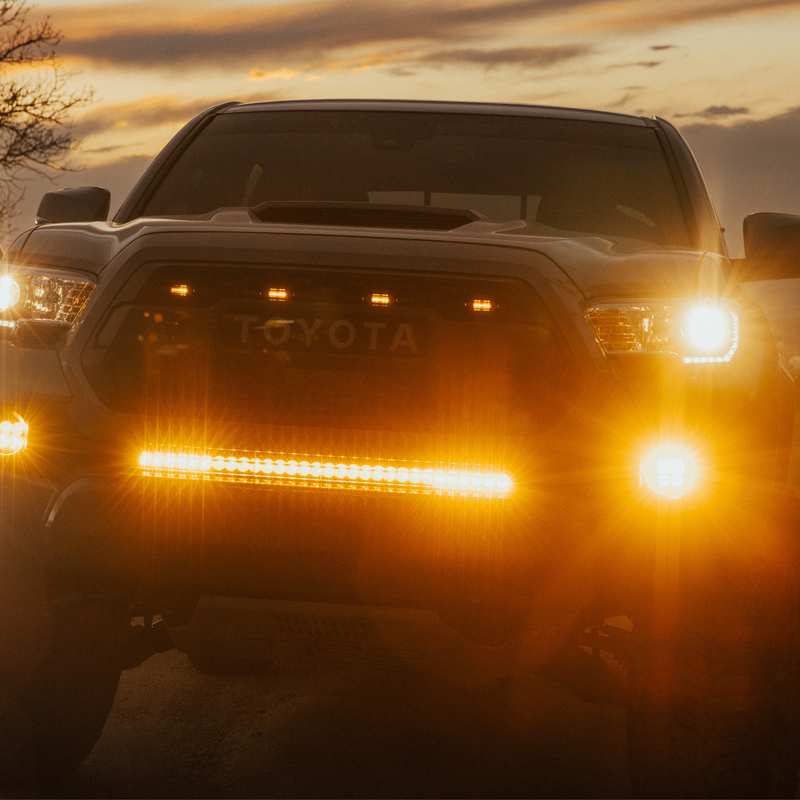 Load image into Gallery viewer, amber LED behind the grille light bar mounted on a toyota tacoma