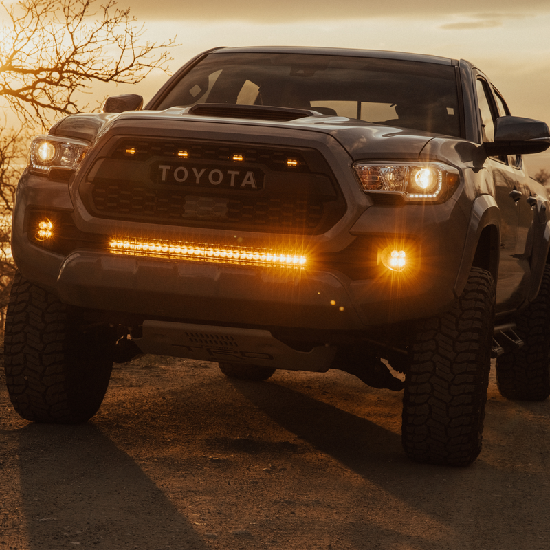 Load image into Gallery viewer,  amber led behind the grille light bar mounted on a toyota tacoma
